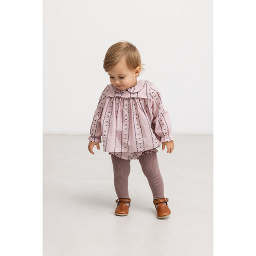 Bloomers Pava Dusty Purple Bloom – 100% katoen – MarMar Copenhagen: Stehendes Kind trägt das bestickte Höschen unter einer Bluse.
