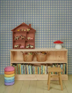 Gingham Ruiten Lichtblauw – Atelier Chien: Tapete hinter einem Holzschrank mit Büchern und Spielzeug.