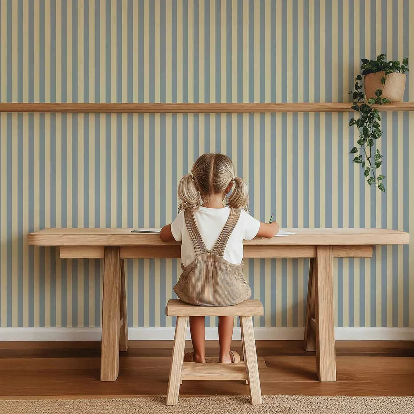Smalle Strepen Lichtblauw – Atelier Chien: wallpaper behind a child sitting at a wooden table.
