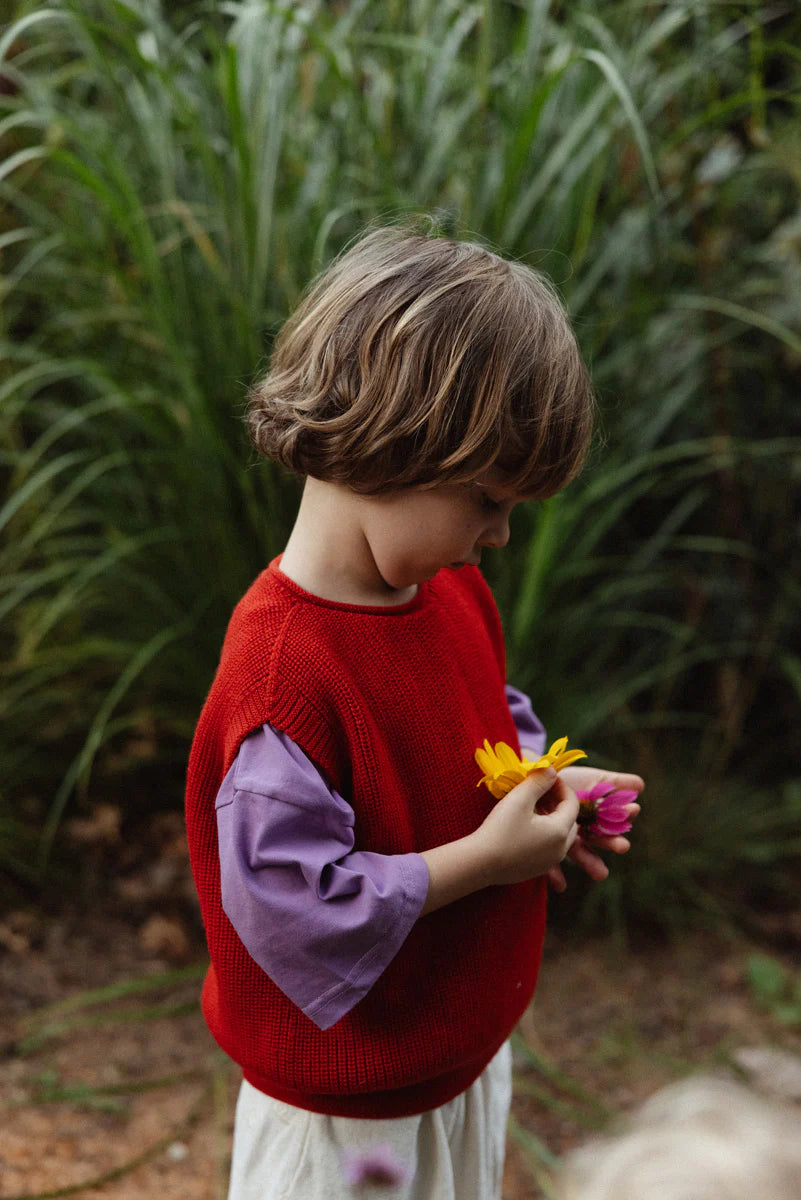 Vest Harvey Kids - 100% extra fine Italiaanse merino wol - HVID - sfeerbeeld met bloemen