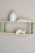 Bibiola Shelf Multi – Bloomingville MINI: Wandregal an der Wand mit Büchern und einer kleinen Lampe.