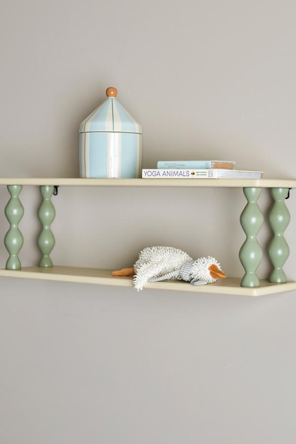 Bibiola Shelf Multi – Bloomingville MINI: Wandregal an der Wand mit Büchern und einer kleinen Lampe.