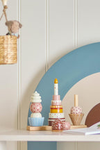 Celebrate Activity Toy – Bloomingville MINI: Stapelspielzeug auf einem Regal im Kinderzimmer.