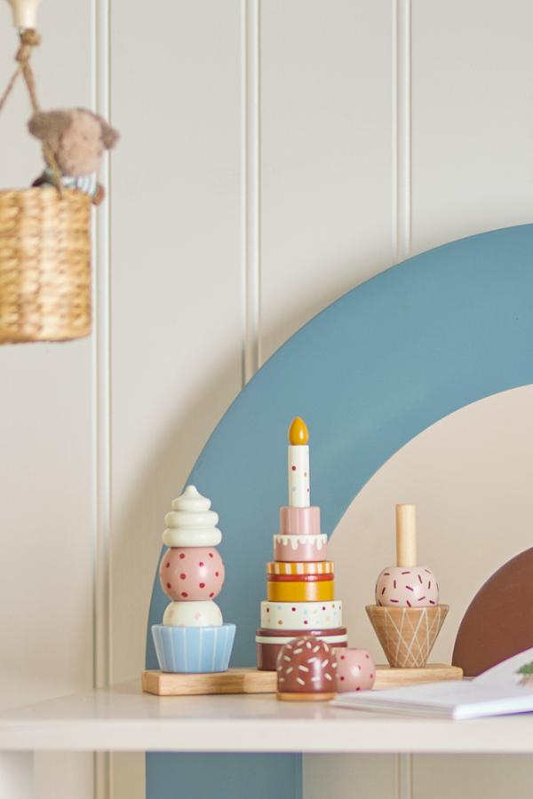 Celebrate Activity Toy – Bloomingville MINI: Stapelspielzeug auf einem Regal im Kinderzimmer.