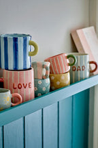 Cherish Mug Rose – Bloomingville : plusieurs tasses colorées posées sur un meuble.